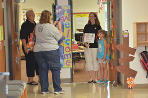 Pam Wright takes a photo of her daughter Megan with first grade teacher Dianne Gunderson (kindergarten teacher Brenda Siems is lookign on)