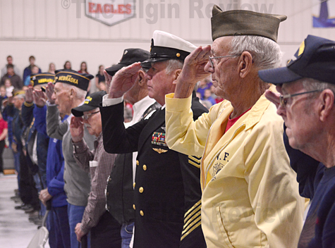 Veterans in attendance salute the flag. The Elgin Review
